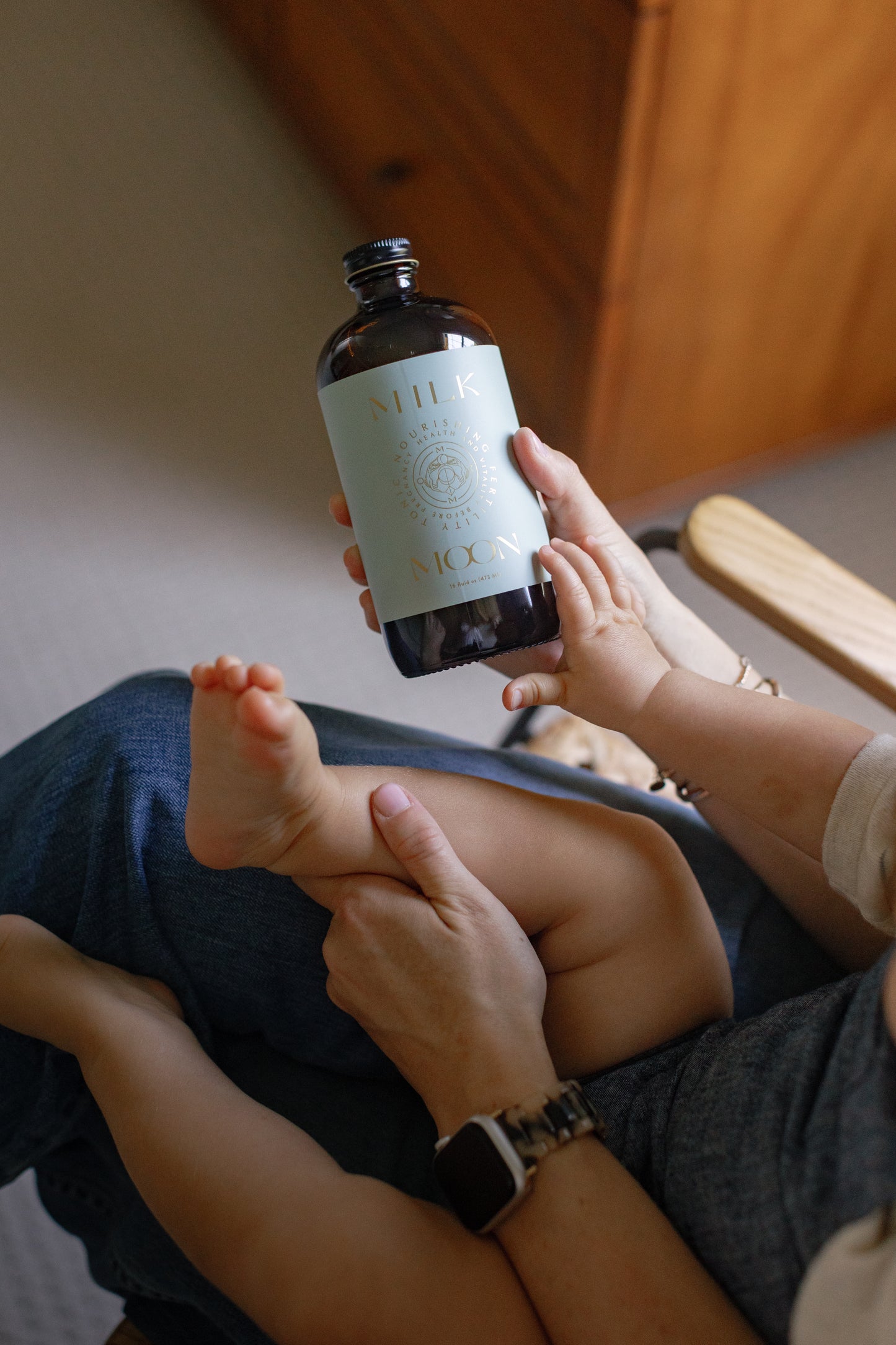 Image of a mother holding her baby and the Nourishing Fertility Tonic