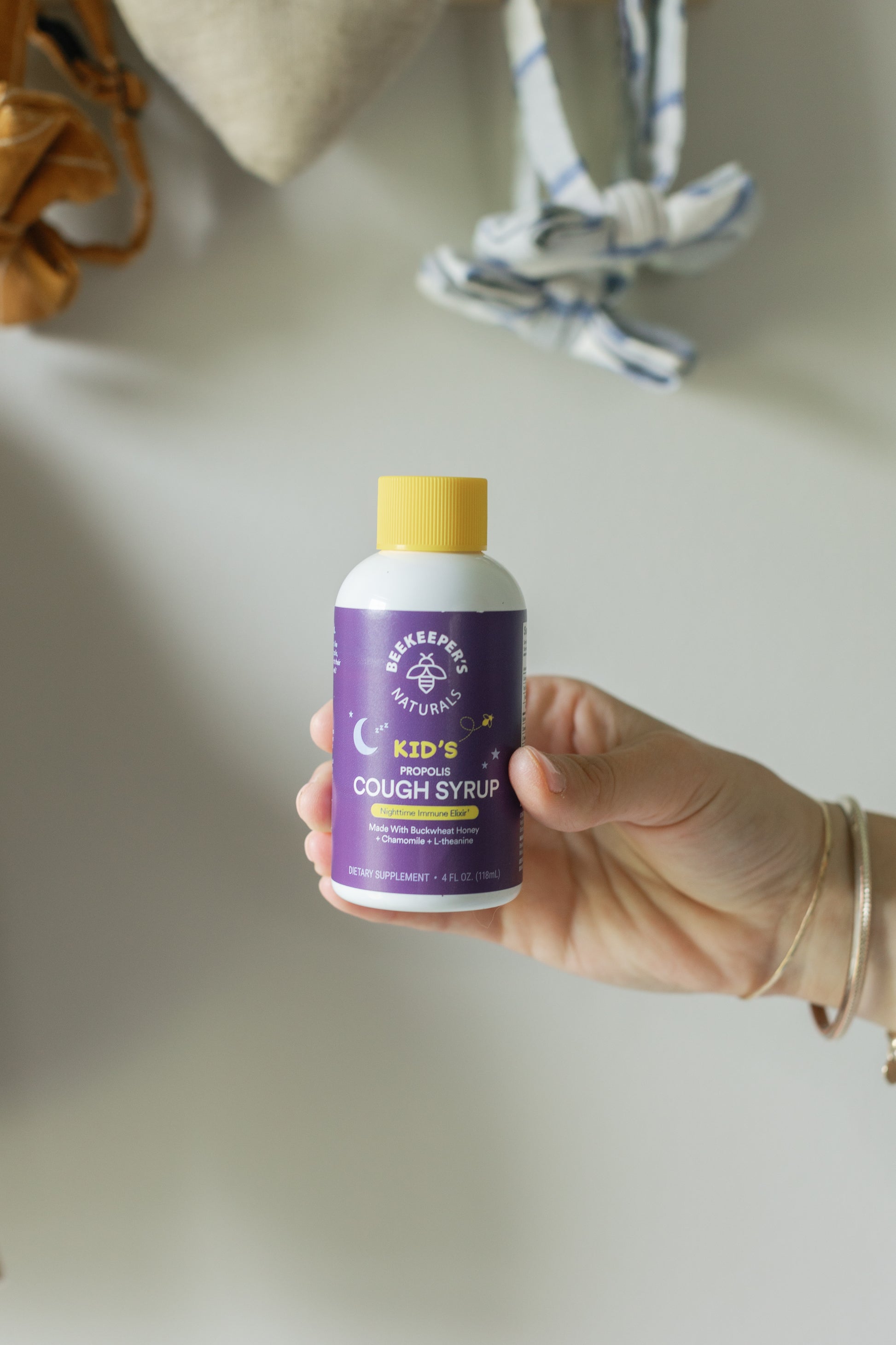 Picture of a hand holding the Kids Propolis Cough Syrup