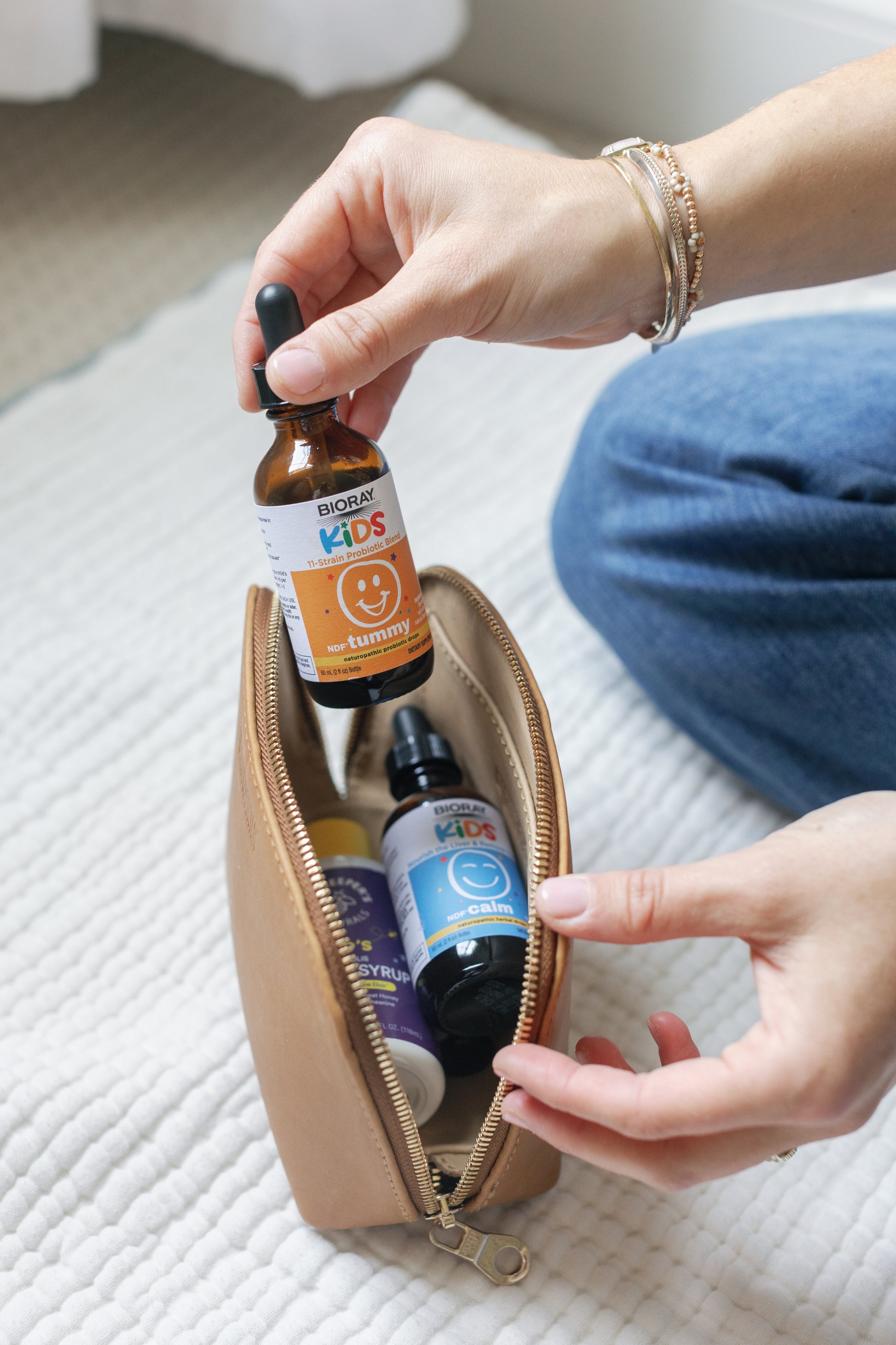 Image of a woman with a necessaire containing all NDF products while showing the NDF Tummy