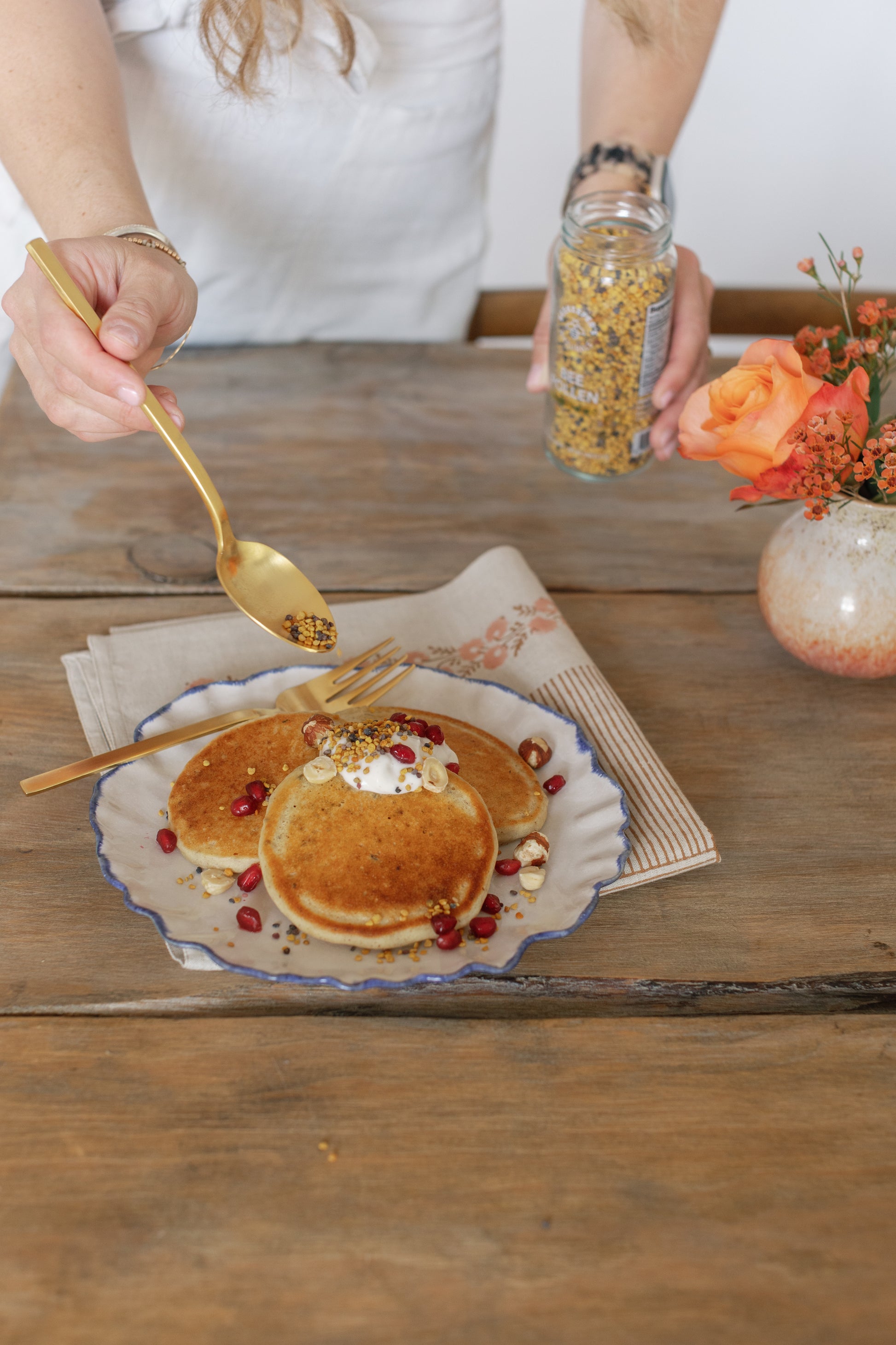 Picture of Caroline putting some Bee Pollen on top of some pancakes