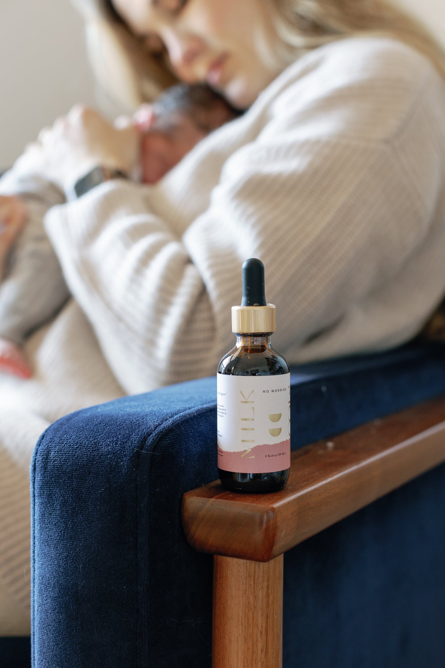 Picture of the No Worries Tonic with Caroline cuddling her baby on the background