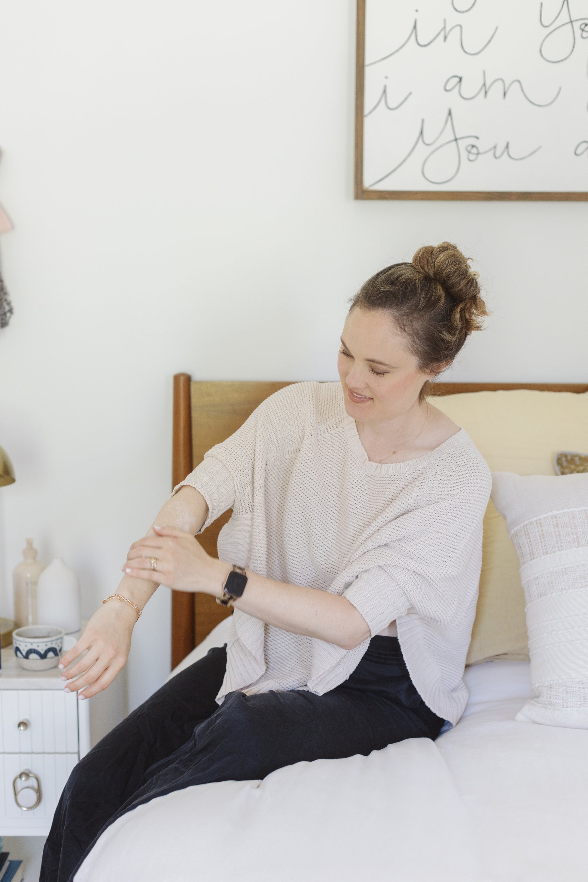 picture of a woman showing the magnesium lotion with MSM and using it on her right arm