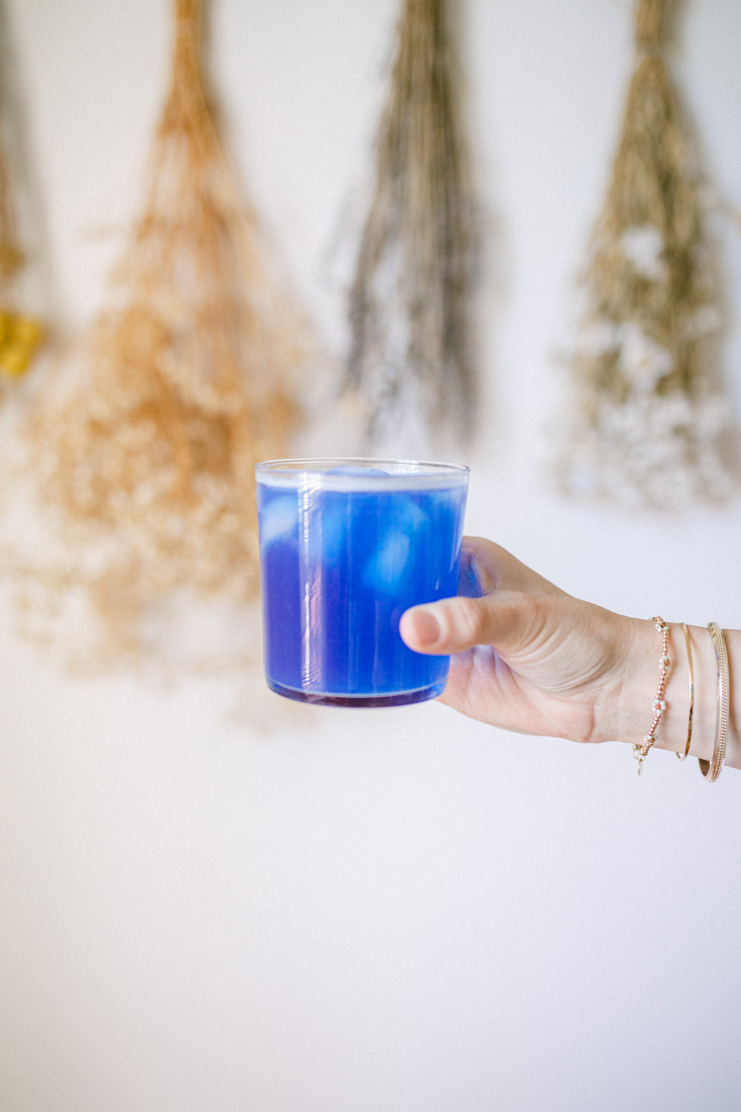 image of a hand honding a cup with the magic magnesium prepared - a vivid blue liquid