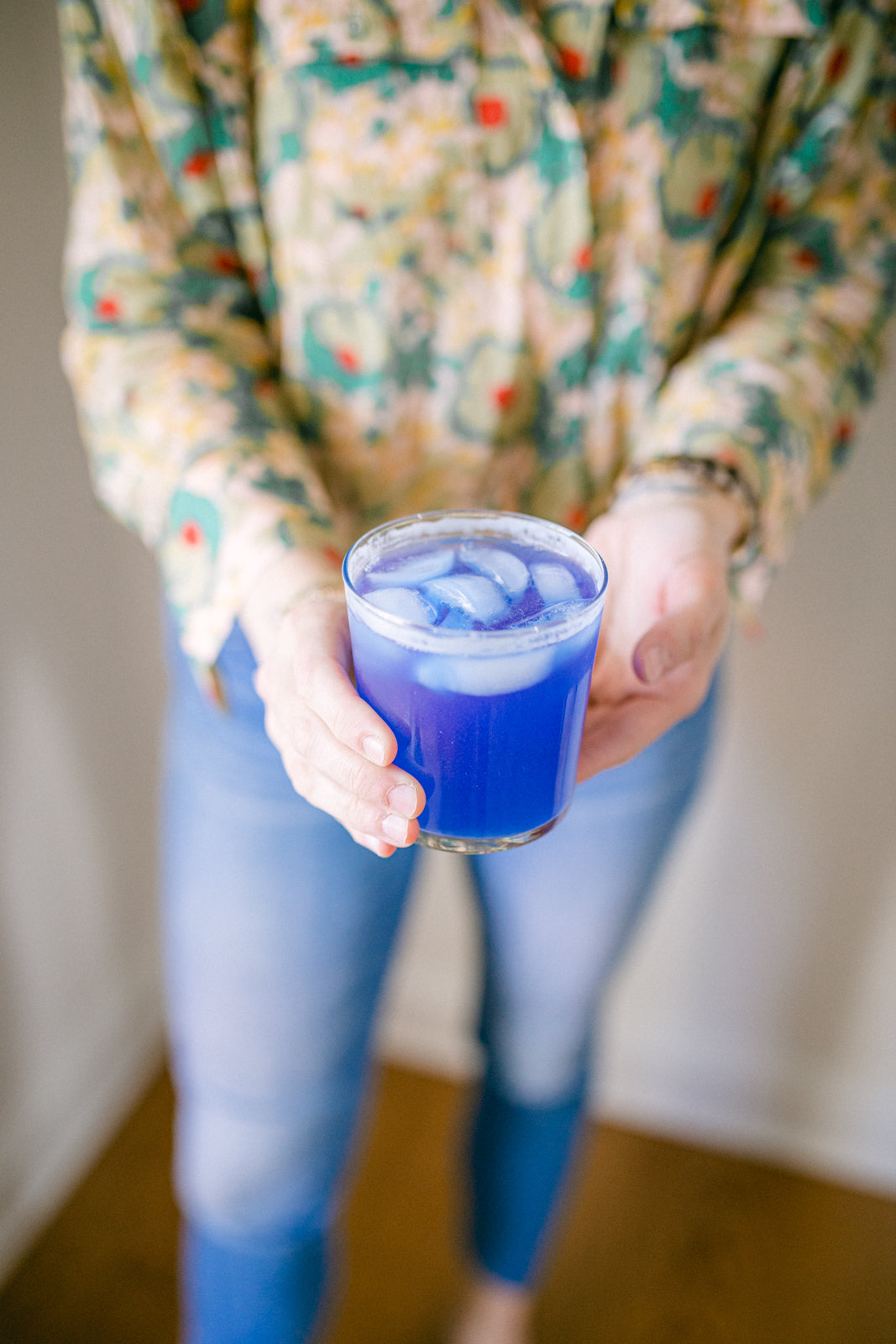 image of a hand holding a cup with the magic magnesium prepared - a vivid blue liquid