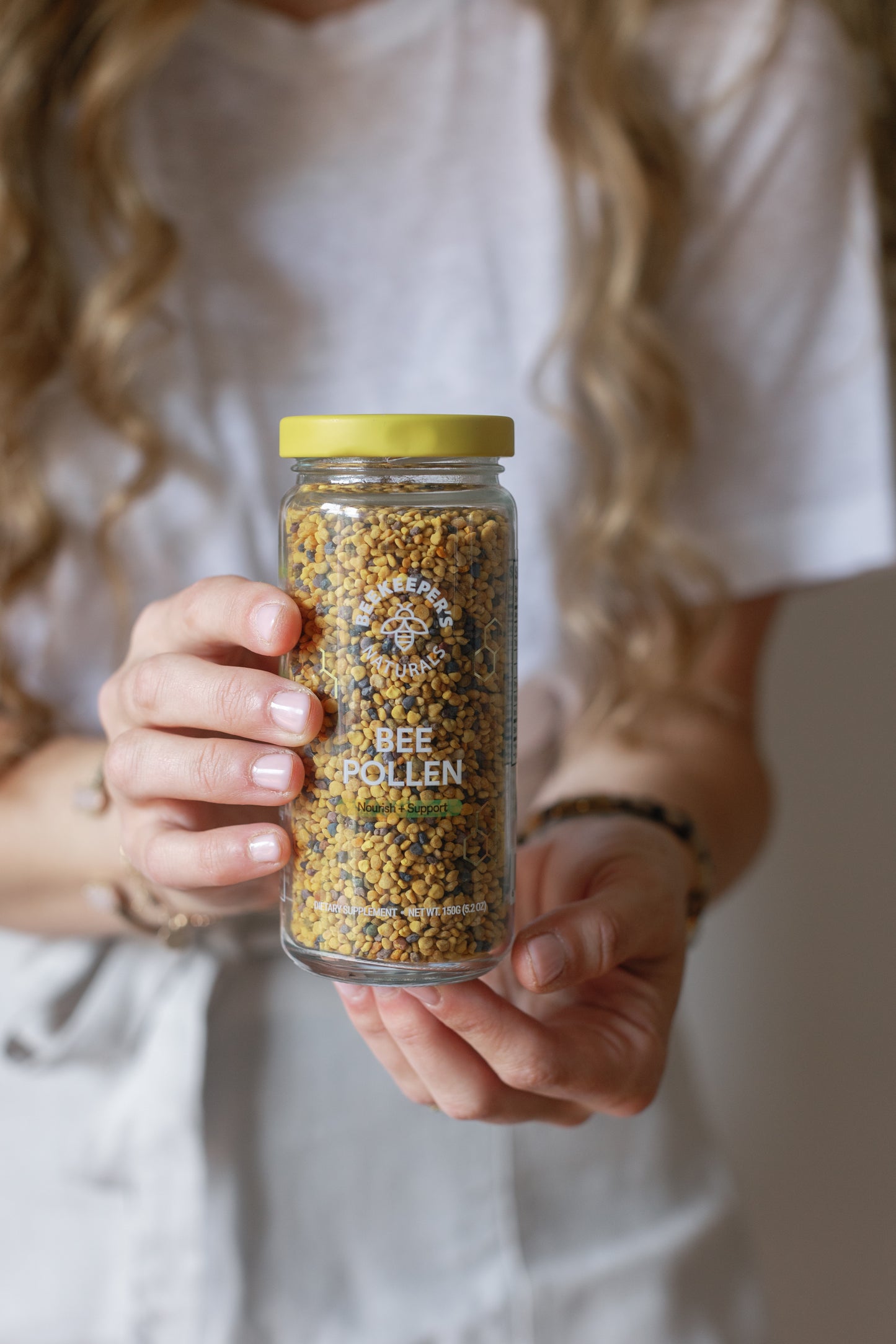 Picture of Caroline holding the packaging for the Bee Pollen product