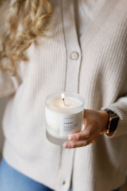 Picture of a person holding a lit Cheer Candle