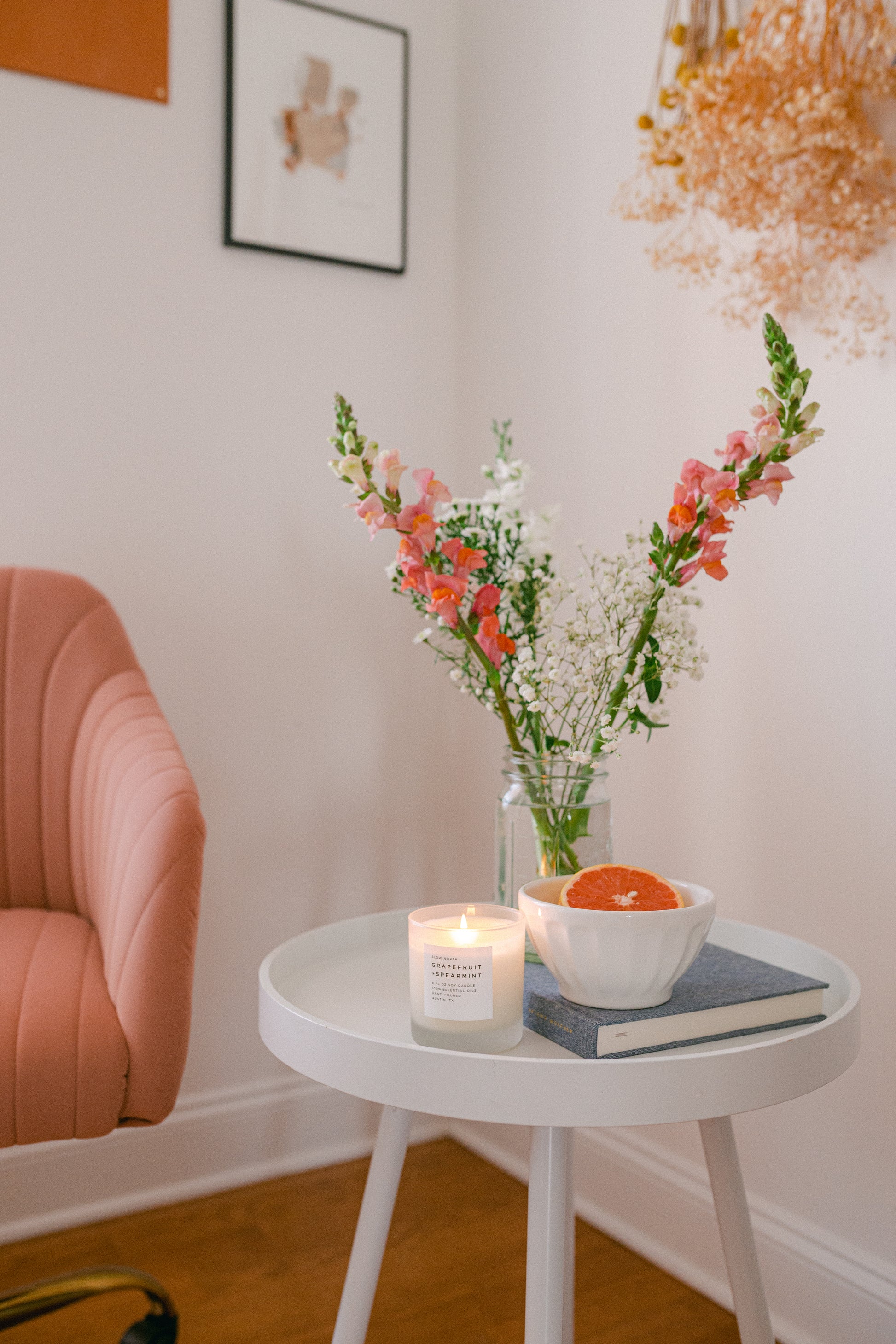 image of a living room corner with a side little table with the grapefruit spearmint candle on top of it