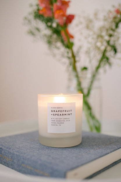 image of a living room corner with a side little table with the grapefruit spearmint candle on top of it
