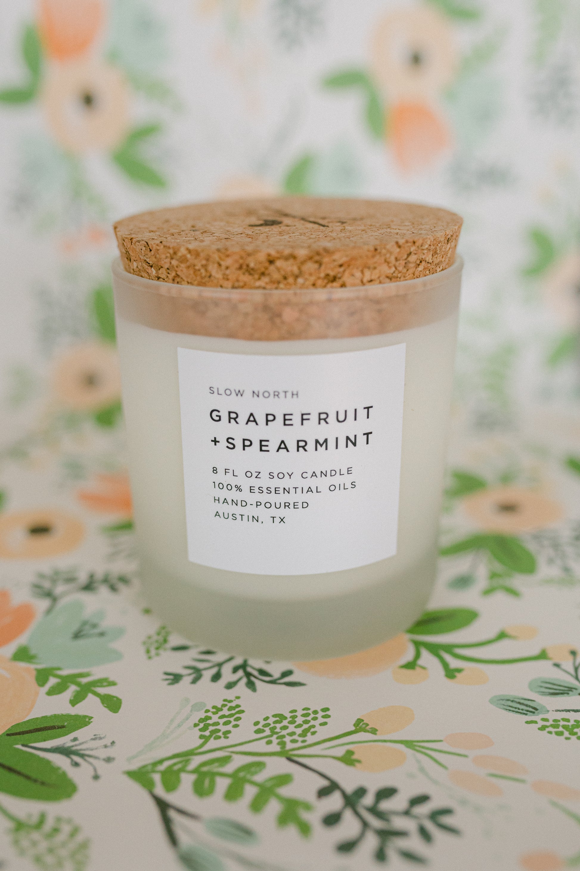 zoom image of a living room corner with a side little table with the grapefruit spearmint candle on top of it