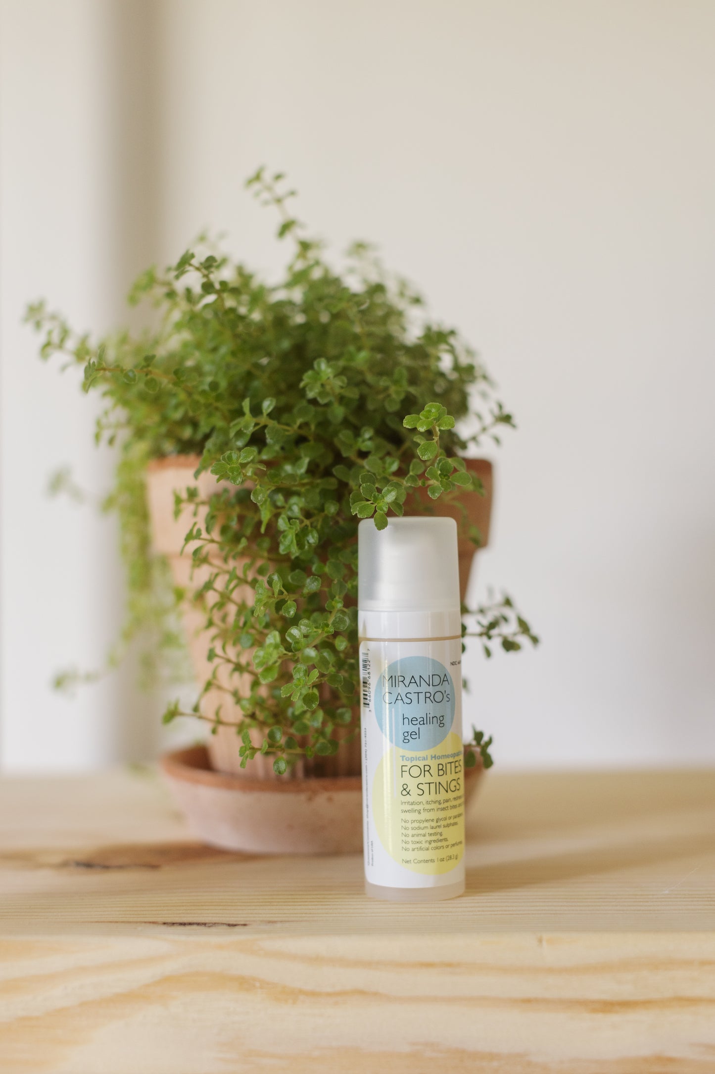 Picture of the Bites & Stings Healing Gel with a green plant behind it
