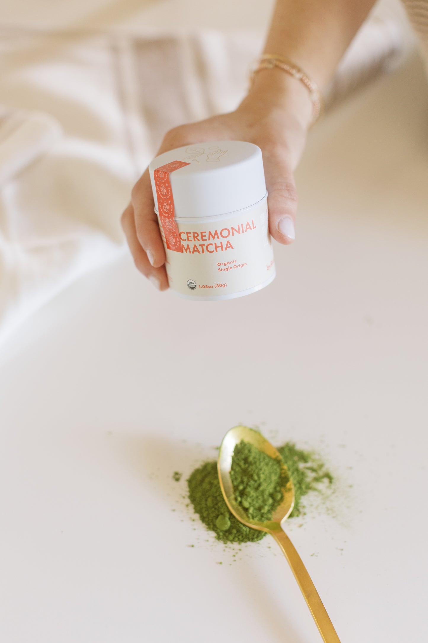 Image of a single hand holding the Ceremonial Matcha container