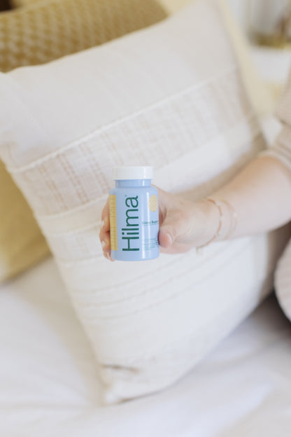 A bottle of Hilma Sleep Support sitting on a bedside table.