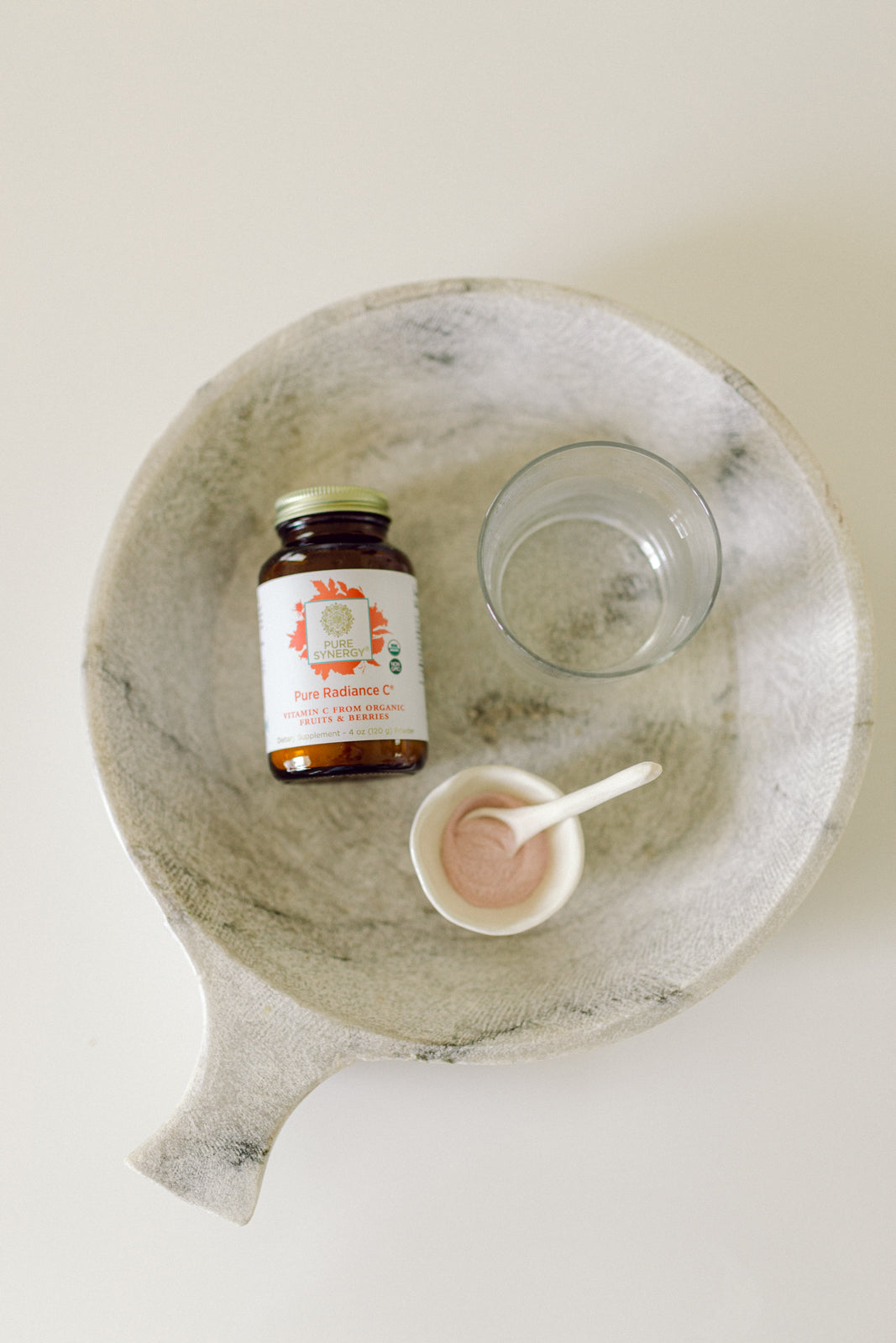 Bottle of Pure Radiance Vitamin C Powder in a bowl