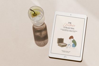 picture of an iPad showing the cover of "The Wellness Collective" with a peach drink on the side